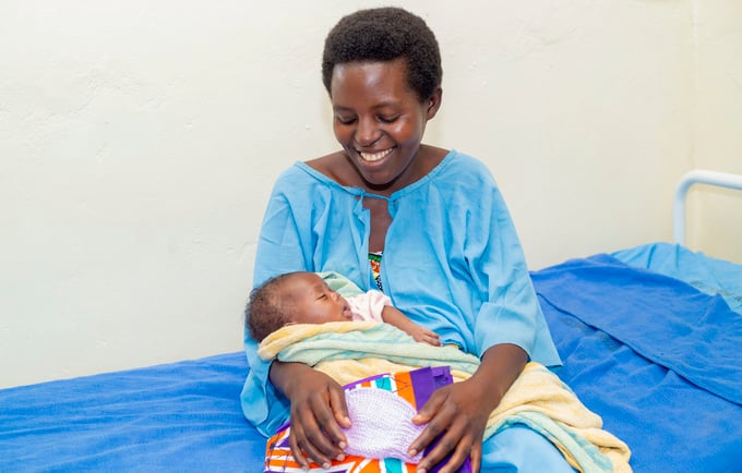 A happy mother smiling at her new born at Kirehe Hospital, Rwanda (Photo: Andre Rugema, RBC, 2019)