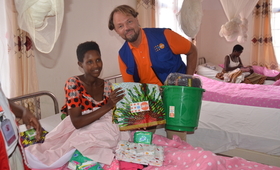 A refugee new mother receives a dignity kit after a few hours of birth from Mr. Mark Bryan Schreiner, UNFPA Rep.